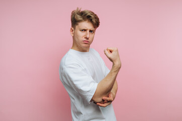 portrait of young determined man strikes a pose with a serious facial expression, showcasing a...