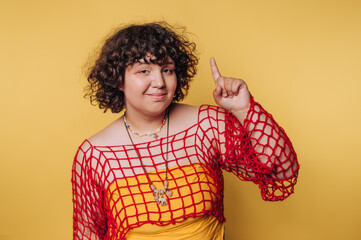portrait of young woman displays charm and playfulness in a vibrant outfit, touching her finger to...