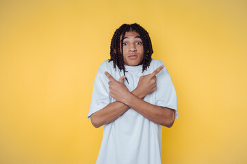 portrait of young man whimsically crosses their arms, indicating confusion and uncertainty on...