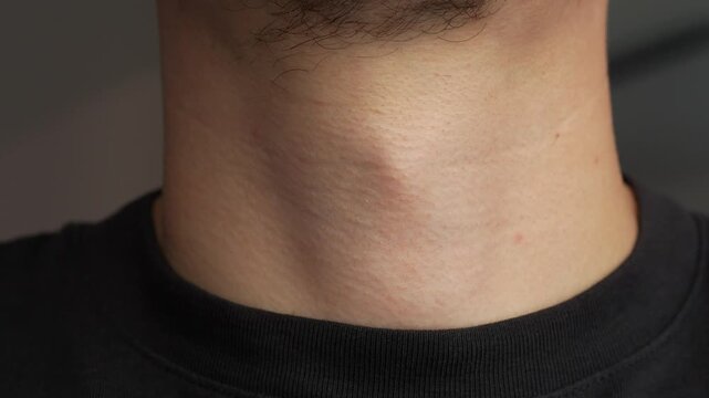 Male kazhik on a man's throat.
A man takes a slurp close-up.
A man swallows something and the movement of the Adam's apple and throat on the neck close-up