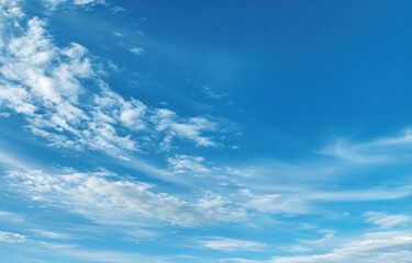 A vibrant blue sky with wispy, white clouds
