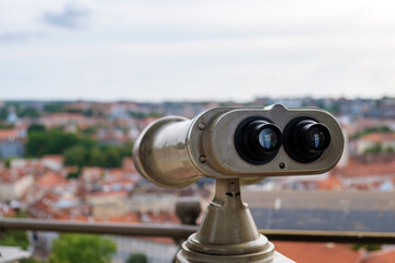 Coin operated binocular viewer on blurred background of city, selective focus