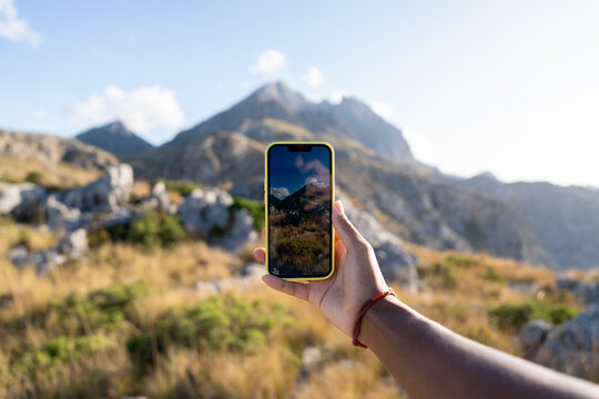 Tourist takes a picture of Puig Major in Majorca mountains using smartphone. Concept of travel, Serra de Tramuntana, photo moment