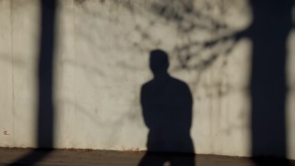 Mysterious Man Shadow Waving Hand against Concrete Wall during Sunny Day
