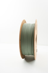 Roll of muted green PLA 3d printer filament on environmental friendly reusable cardboard roll...