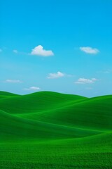 Rolling green hills under a clear blue sky with scattered white clouds forming a landscape