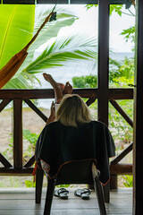 Tourist relaxing with phone on balcony overlooking tropical scenery in colombia