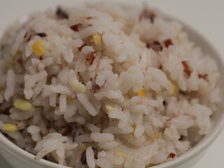 Rice cooked with grain mix in white bowl, isolated