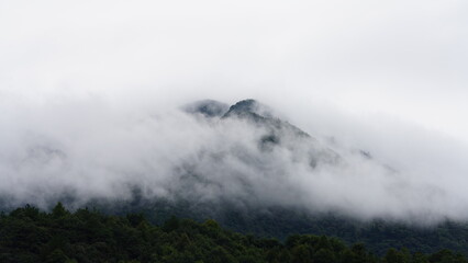 The beautiful mountains view with the covered fog on them