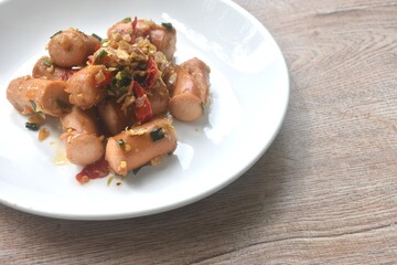 deep fried salty pork sausage with chop garlic and chili pepper arranging on plate 