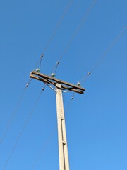 Poste de electricidad de cemento con líneas eléctricas aéreas