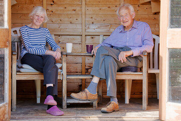 Senior elderly couple in summerhouse during summer