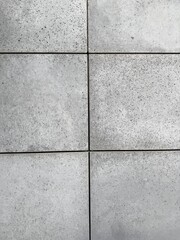 Close-up view of facade tiles crafted from architectural concrete, highlighting their smooth surface, modern texture, and geometric arrangement.