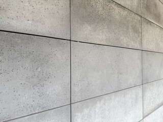 Close-up view of facade tiles crafted from architectural concrete, highlighting their smooth surface, modern texture, and geometric arrangement.