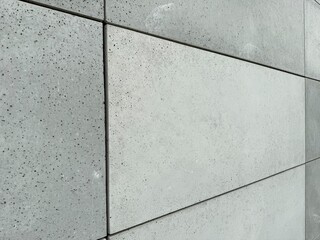 Close-up view of facade tiles crafted from architectural concrete, highlighting their smooth surface, modern texture, and geometric arrangement.