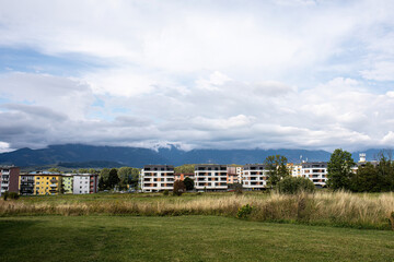 Modern apartment buildings on green field with mountain view
