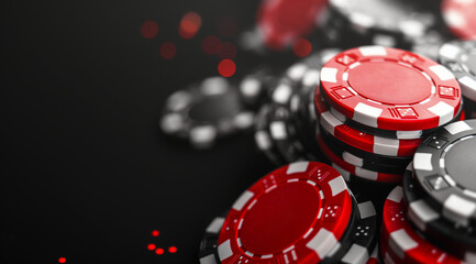 Red and Black Gambling Chips Piled on Dark Casino Surface for Poker Game Concept