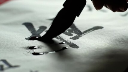 Hand writing traditional calligraphy with a brush and flowing ink on paper - Powered by Adobe