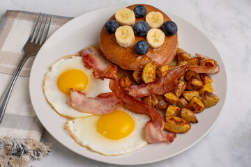 fried eggs with pancakes and bacon