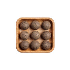 Overhead View of Nine Dark Brown Herbal Balls in Wooden Tray