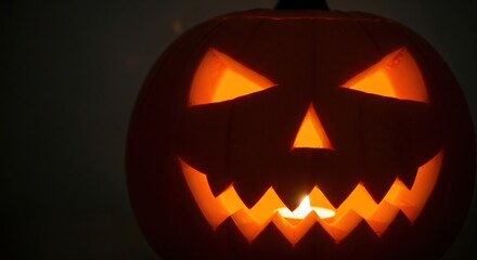 Fototapeta premium Glowing jack-o'-lantern with a carved face, creating a spooky and festive Halloween atmosphere