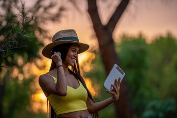Fototapeta premium Woman Taking Selfie in Park at Sunset