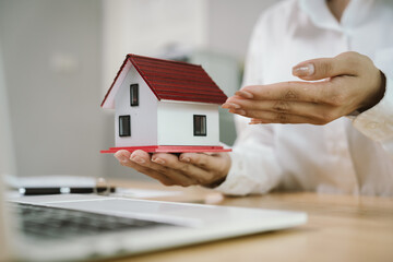A real estate agent hands over keys after signing a property contract, symbolizing investment,...