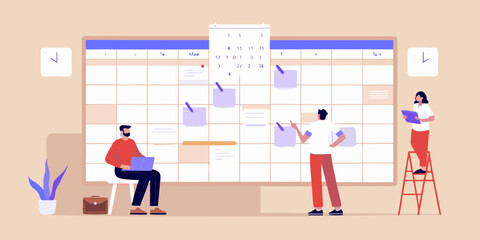 Team collaborating on a large wall calendar planning tasks and projects with sticky notes and a laptop