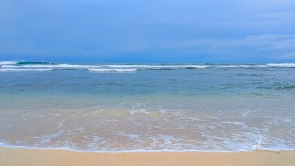 Serene Tropical Beach and Ocean Waves with Blue Sky Serenity at Sundak Beach in Gunungkidul, Yogyakarta, Indonesia
