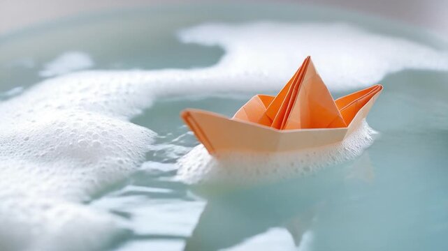 A small paper boat floating in a decorative water bowl