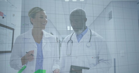 Walking doctors wearing lab coats discussing data in hospital with clipboard, tablet and AR overlay