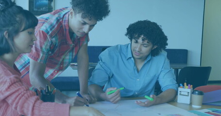 Collaborating three adults sketching plans at study room, with markers and paper