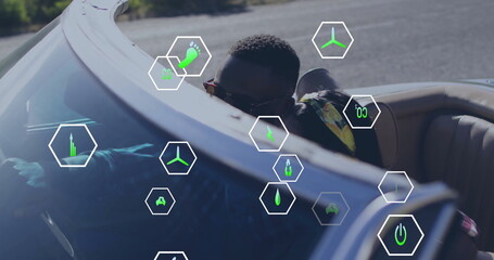 Driving convertible African American man in sunglasses, patterned shirt on road, with hexagon icons