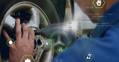 Tightening lug nuts mechanic in blue uniform using impact wrench on wheel in garage, code graphics