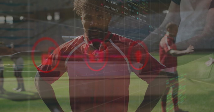 Standing male soccer player wearing red jersey on stadium pitch with translucent analytics overlay - Powered by Adobe