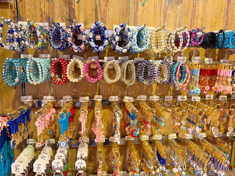 Bracelets with beads, shells and charms for sale in a market. Jewelry, accessory and cultural creativity represented through consumer choice, style and artisan design.