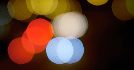 Glowing hexagonal bokeh lights overlapping against dark urban backdrop, creating abstract pattern