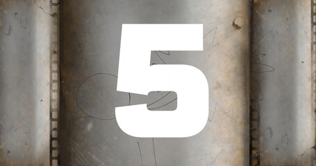 White numeral 5 occupying center in scratched countdown leader, with sprocket-hole perforations