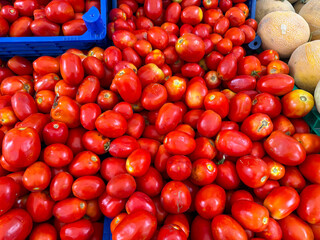 Large red tomatoes with irregular shapes on market stall. Agriculture, farming, and seasonal vegetable harvest with healthy nutrition lifestyle.
