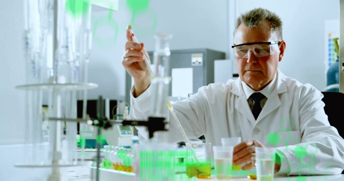 Pipetting chemist wearing lab coat and goggles measuring samples at lab bench, with glassware
