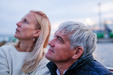 Old couple enjoying life together on a boat, gazing at the sky, surrounded by nature, capturing elegance and style in a serene atmosphere with copy space