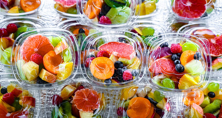 Boxes with pre-packaged fruit salads in a commercial fridge