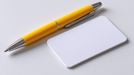 A simple white name card lies next to a bright yellow pen on a smooth light surface, suitable for jotting down names or contact information at a networking event or business meeting