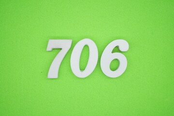 The numbers are made of white painted wood and placed on a green paper background.