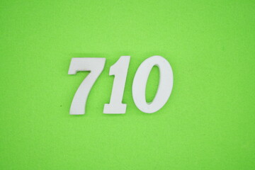 The numbers are made of white painted wood and placed on a green paper background.