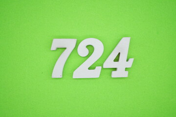 The numbers are made of white painted wood and placed on a green paper background.