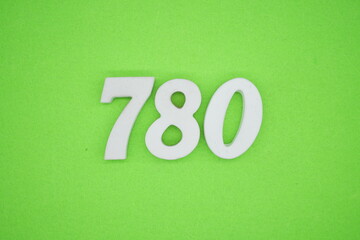 The numbers are made of white painted wood and placed on a green paper background.
