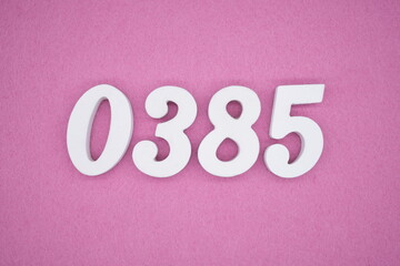The numbers are made of white painted wood, placed on a pink paper background.