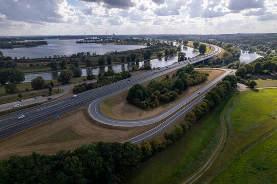 Exit off of a348 with river IJssel valley in the background. Infrastructure and inland shipping waterway in dramatic cloud shadowplay Dutch landscape