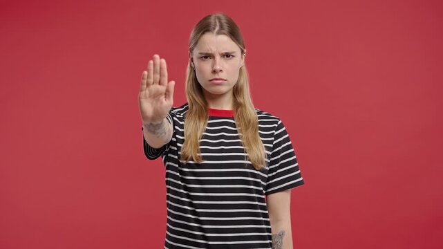 Serious woman with open palm in stop gesture, clear assertive body language